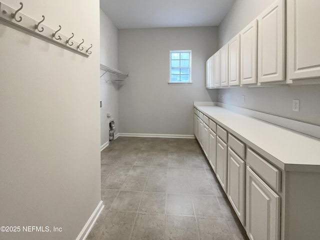 clothes washing area featuring cabinet space, baseboards, and hookup for an electric dryer