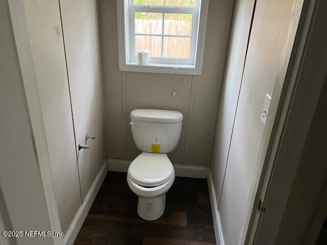 bathroom featuring toilet, wood finished floors, and baseboards