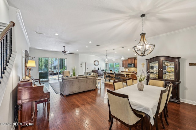 dining area featuring stairs, dark wood finished floors, visible vents, and ornamental molding