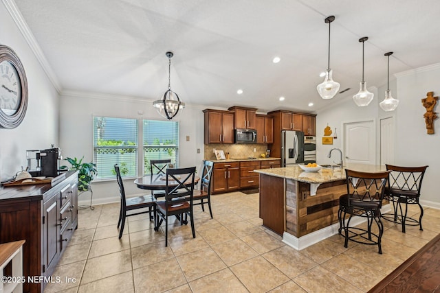 kitchen with a breakfast bar area, a sink, ornamental molding, stainless steel appliances, and backsplash