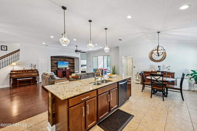 kitchen with ceiling fan with notable chandelier, dishwasher, pendant lighting, and a sink