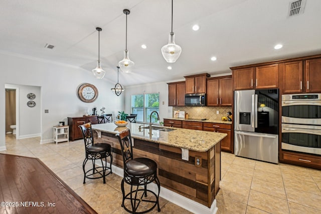 kitchen featuring lofted ceiling, a sink, stainless steel appliances, a kitchen bar, and tasteful backsplash