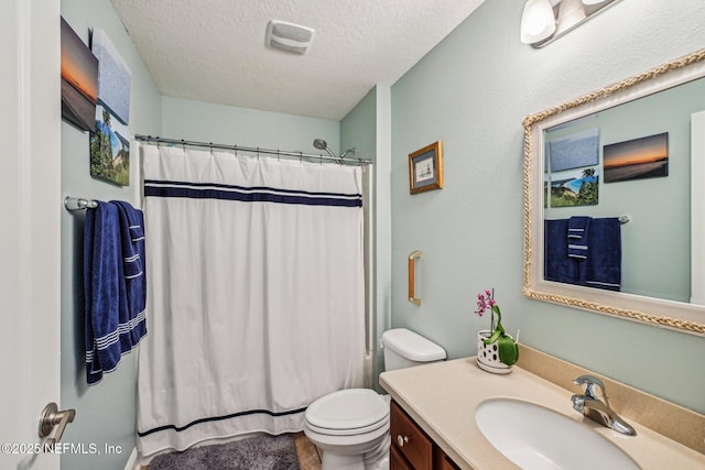 bathroom with vanity, toilet, a shower with curtain, and a textured ceiling