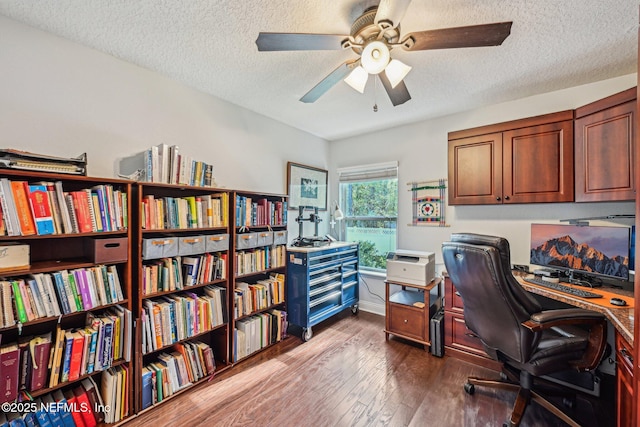 office space featuring baseboards, a textured ceiling, dark wood-type flooring, and ceiling fan