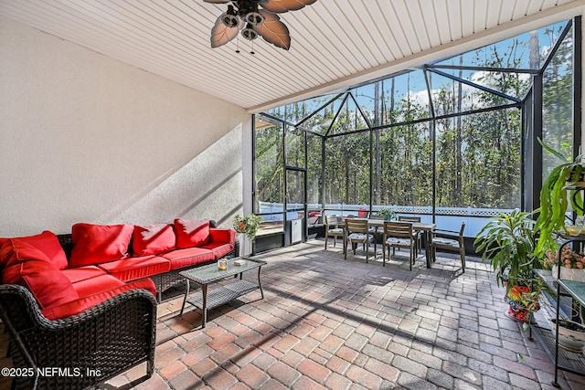 view of patio / terrace featuring an outdoor living space, outdoor dining area, a lanai, and a ceiling fan