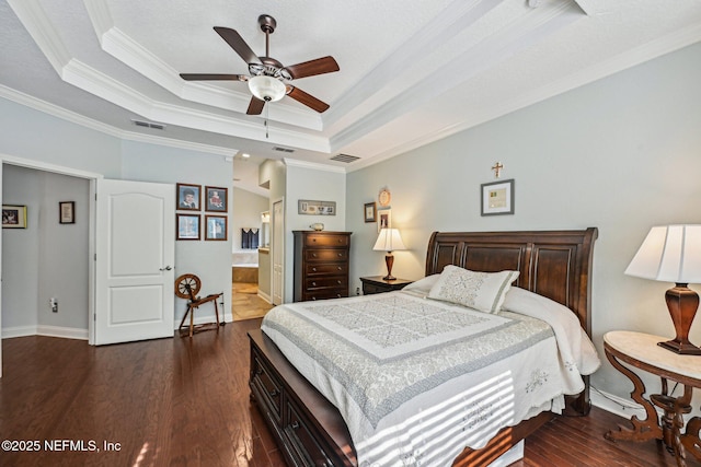 bedroom featuring visible vents, crown molding, a tray ceiling, and dark wood-style flooring