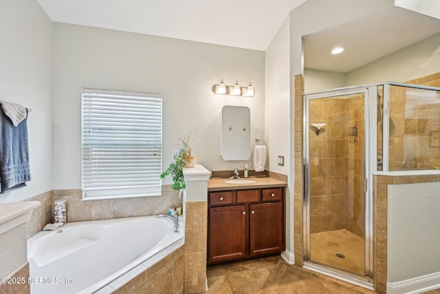 full bathroom featuring vanity, a shower stall, a garden tub, and tile patterned flooring