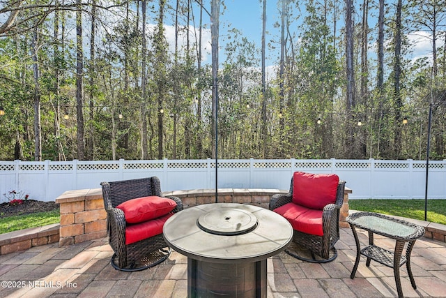 view of patio / terrace with a fenced backyard and a wooded view