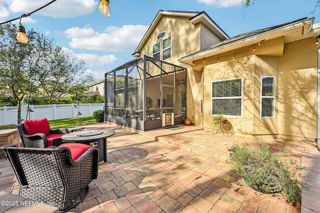 view of patio featuring glass enclosure and fence