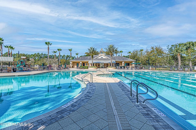 pool with playground community, a patio, and fence