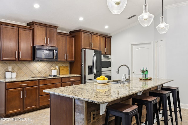 741 W Kings College Dr, Saint Johns, FL 32259 - kitchen featuring appliances with stainless steel finishes, ornamental molding, tasteful backsplash, lofted ceiling, and a kitchen island with sink
