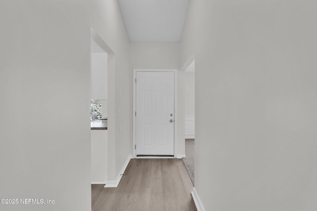 hall featuring baseboards and wood finished floors