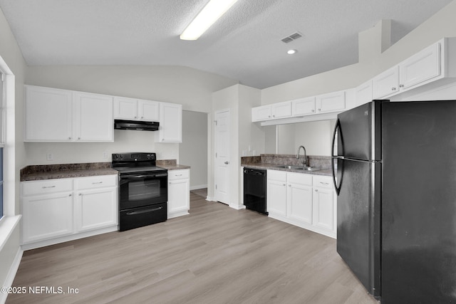 kitchen with visible vents, under cabinet range hood, vaulted ceiling, black appliances, and a sink