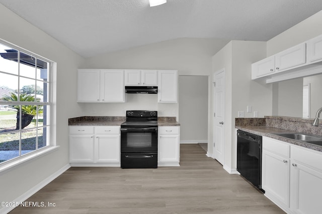 kitchen featuring white cabinets, under cabinet range hood, vaulted ceiling, black appliances, and a sink