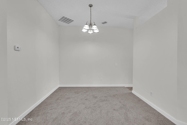 carpeted empty room with baseboards, visible vents, and a notable chandelier