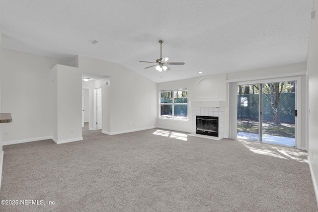 unfurnished living room featuring lofted ceiling, carpet floors, a fireplace, visible vents, and baseboards