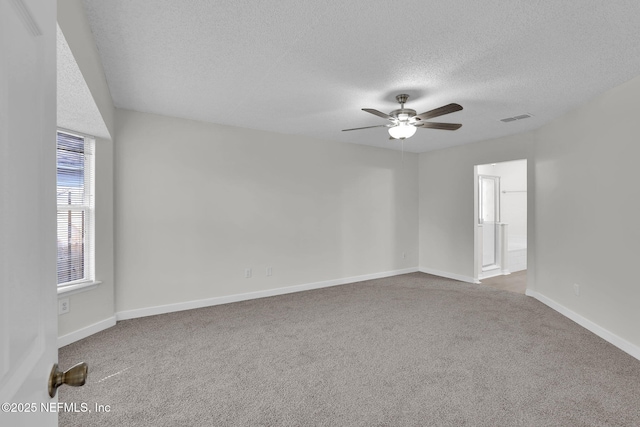 empty room featuring baseboards, visible vents, ceiling fan, a textured ceiling, and carpet floors