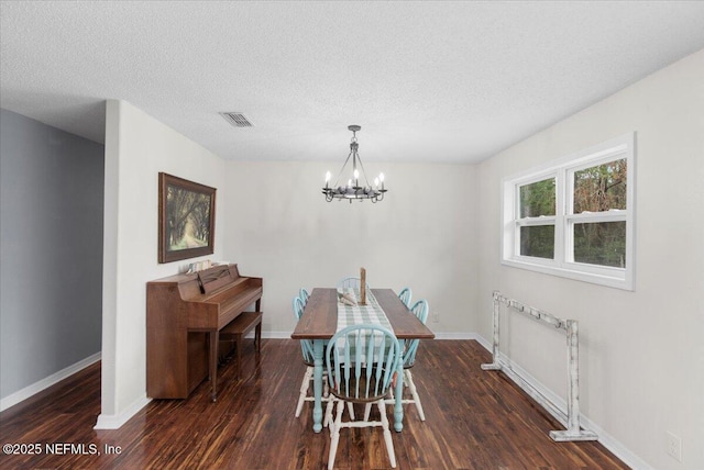 dining area featuring baseboards, wood finished floors, visible vents, and a notable chandelier