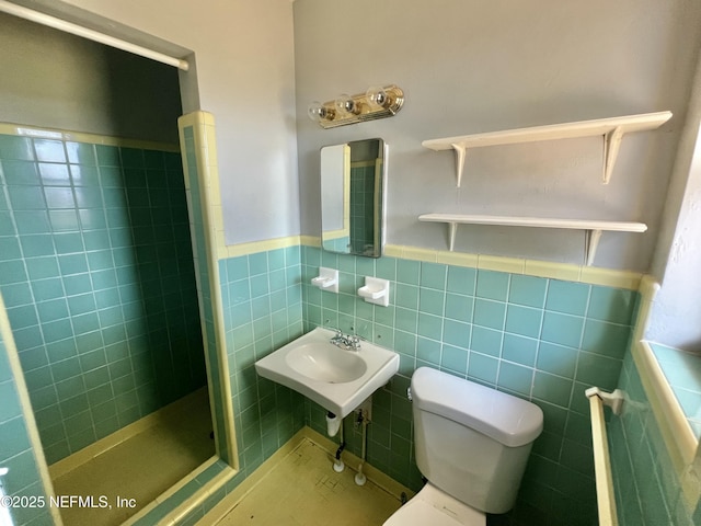 full bathroom featuring toilet, a wainscoted wall, a shower stall, and tile walls