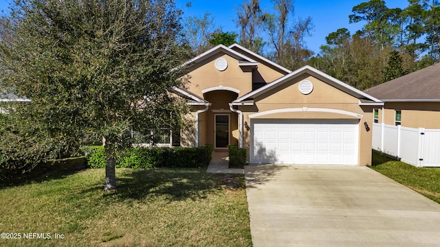 view of front facade with stucco siding, driveway, fence, an attached garage, and a front yard