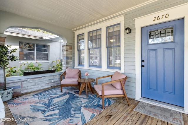 view of exterior entry featuring covered porch