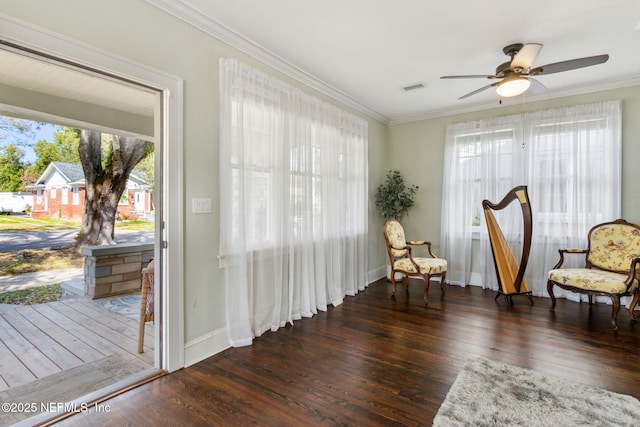 sitting room featuring crown molding, visible vents, ceiling fan, wood finished floors, and baseboards