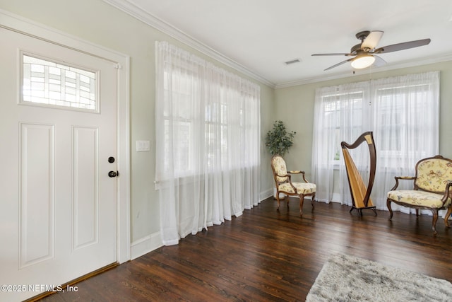 sitting room with ornamental molding, dark wood finished floors, visible vents, and plenty of natural light