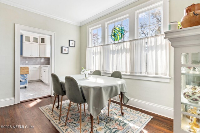 dining area featuring crown molding, baseboards, dark wood-style flooring, and a wealth of natural light