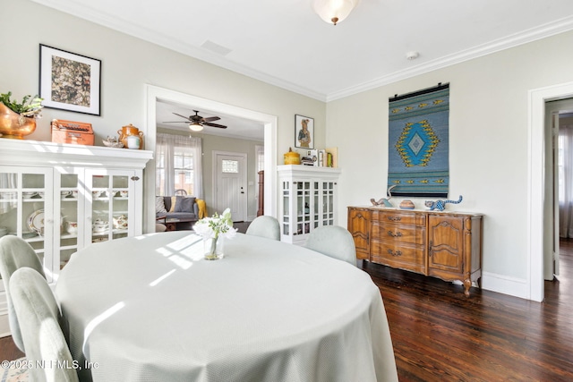 dining room with baseboards, wood finished floors, and crown molding