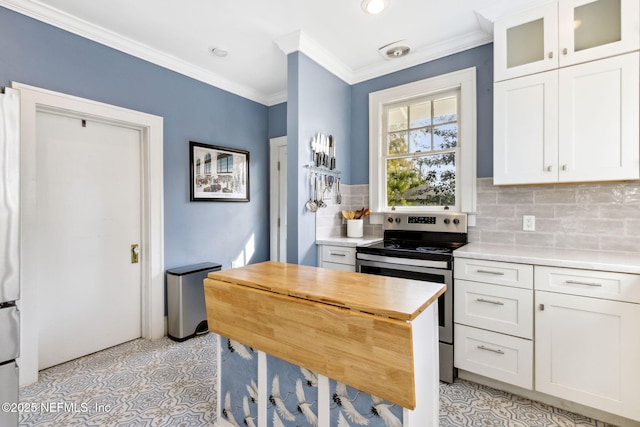 kitchen featuring wooden counters, backsplash, electric range, ornamental molding, and white cabinets