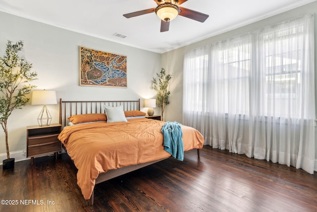 bedroom with ceiling fan, visible vents, and wood finished floors