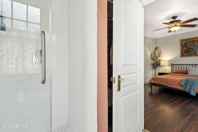 full bathroom featuring ceiling fan, tiled shower, connected bathroom, and wood finished floors