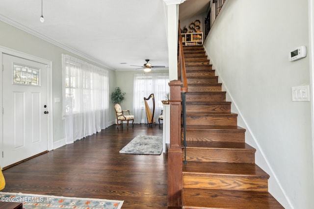 stairs with a ceiling fan, crown molding, baseboards, and wood finished floors