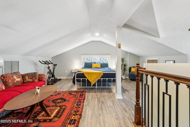 bedroom with lofted ceiling, baseboards, and wood finished floors