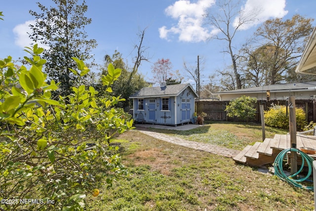 view of yard featuring a fenced backyard, an outdoor structure, and a storage shed