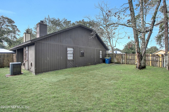 view of home's exterior featuring a fenced backyard, a chimney, central AC, and a yard