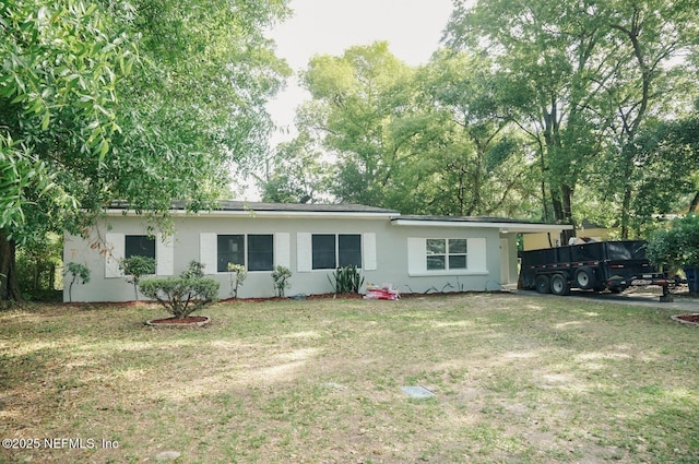 ranch-style house with a front yard and stucco siding