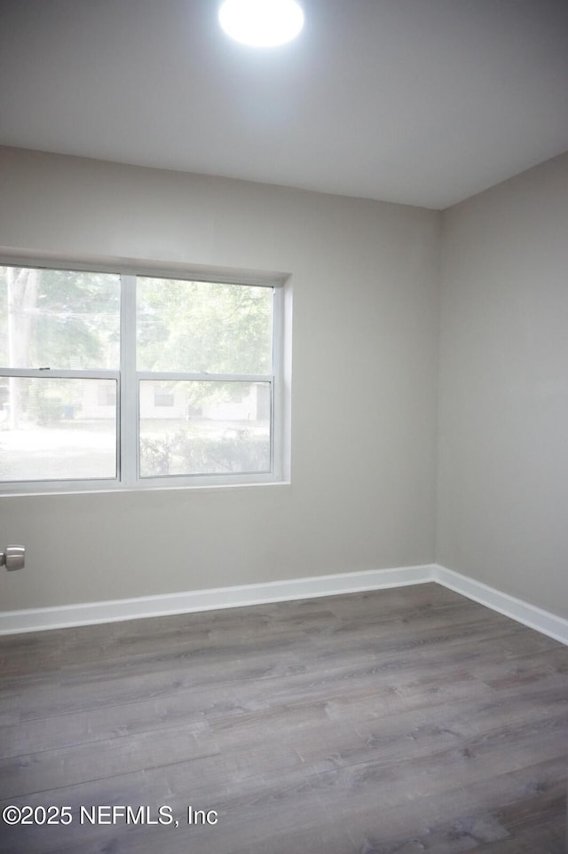 unfurnished room featuring baseboards and wood finished floors