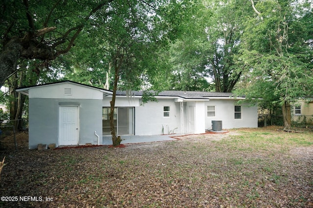 back of property featuring stucco siding, fence, and central AC unit