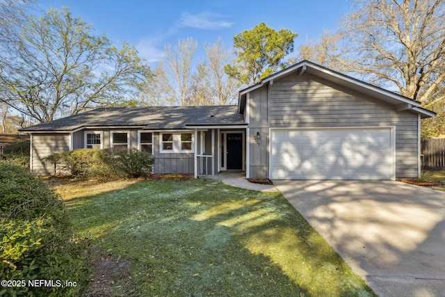 view of front of home with concrete driveway, fence, a garage, and a front yard