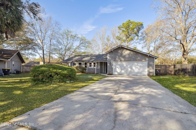 view of front of house featuring a front lawn, fence, a garage, and driveway