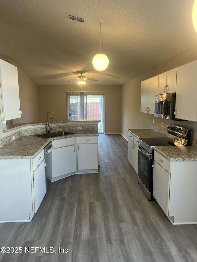 kitchen featuring white cabinetry, visible vents, stainless steel appliances, and dark wood-type flooring