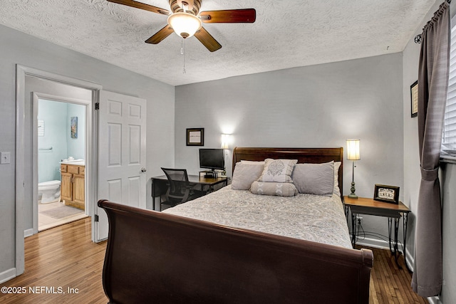 bedroom with baseboards, ensuite bath, ceiling fan, wood finished floors, and a textured ceiling