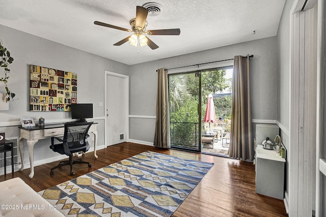 office space with ceiling fan, a textured ceiling, baseboards, and wood finished floors