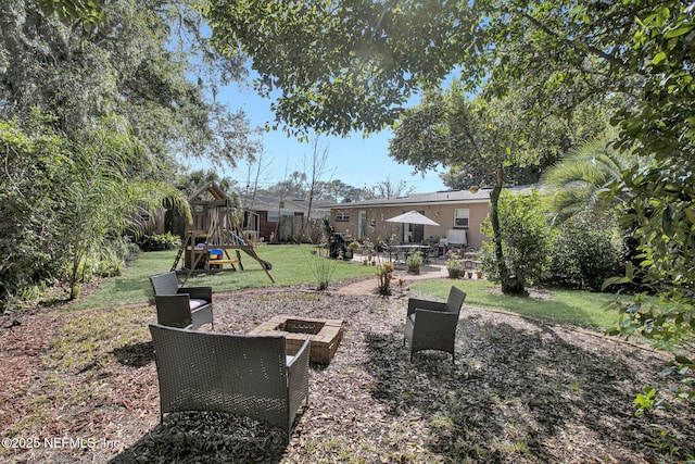 view of yard with a playground, a patio, and a fire pit