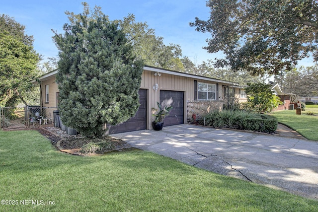 view of front of home with brick siding, an attached garage, a front yard, fence, and driveway