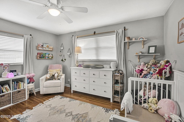 bedroom with ceiling fan, wood finished floors, and baseboards