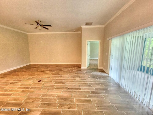 spare room with baseboards, visible vents, ceiling fan, and crown molding