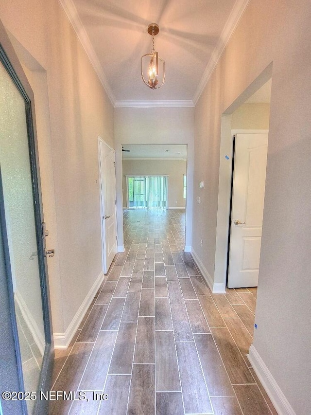 hall with ornamental molding, wood tiled floor, and baseboards