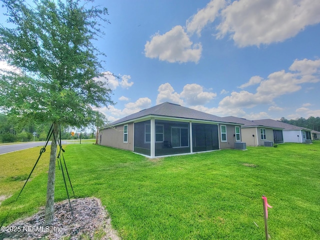 rear view of house with a yard and a sunroom